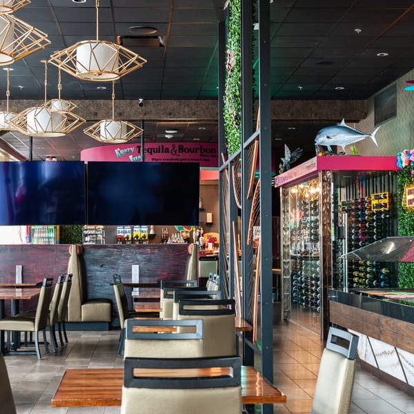 Interior of Krazy Tequila & Bourbon restaurant with tables, booths, decorative lighting, and a wine display.